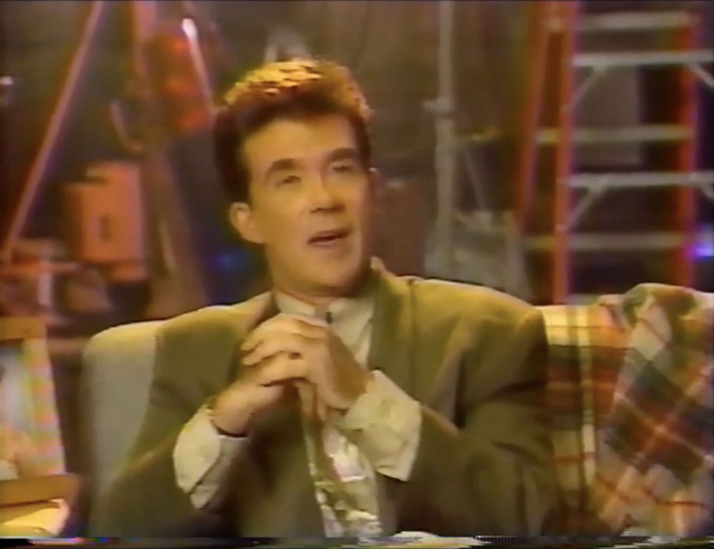 Alan Thicke sitting on a couch