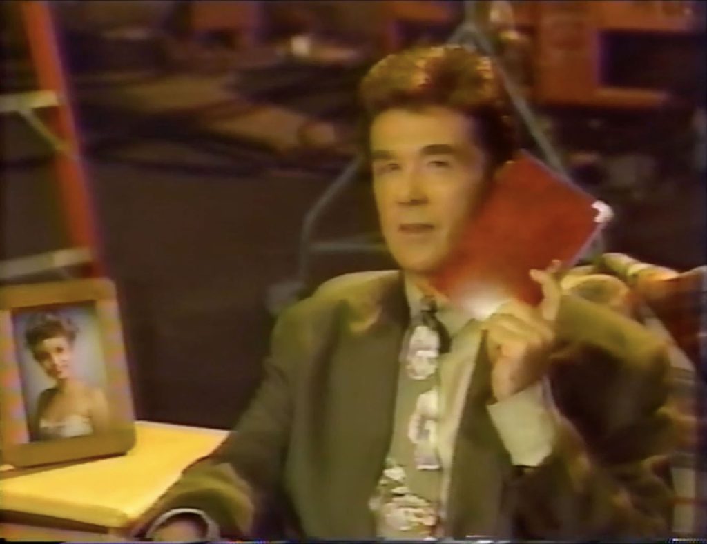 Alan Thicke sitting on a couch holding a diary