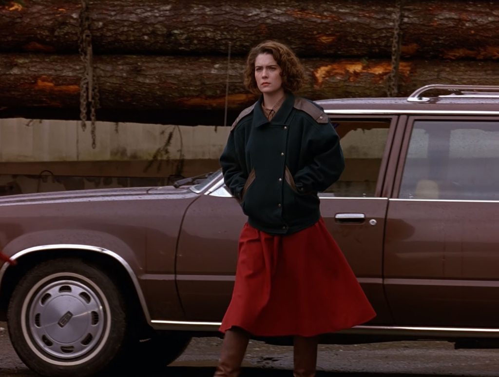 Donna Hayward standing by a brown station wagon