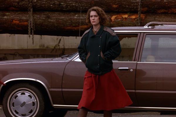 Donna Hayward standing by a brown station wagon