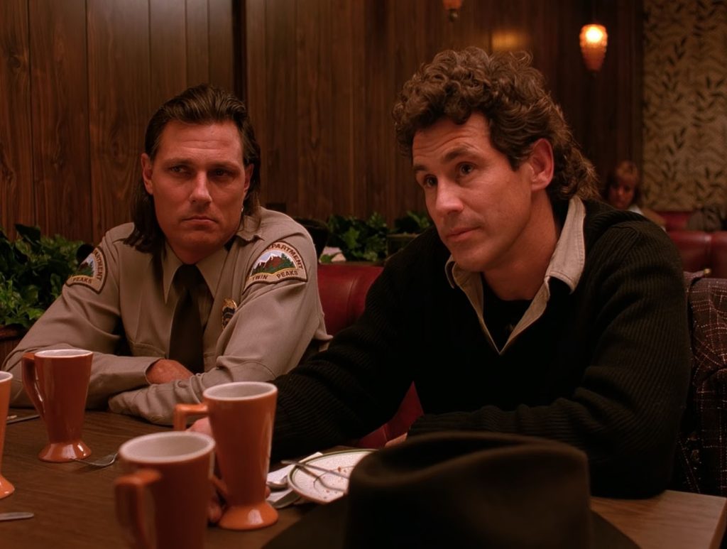 Deputy Hawk and Sheriff Truman sitting in a booth at the Double R Diner