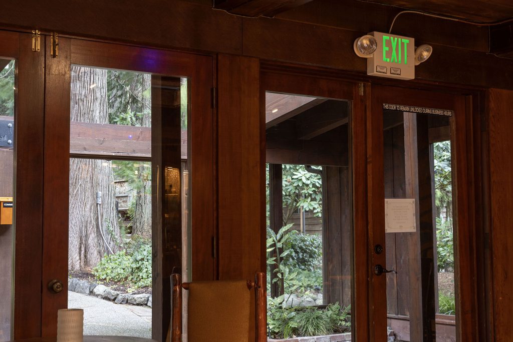 Front doors of Kiana Lodge with a green exit sign