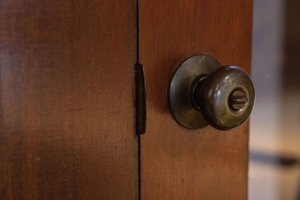 Metal doorknob mounted on a wooden door