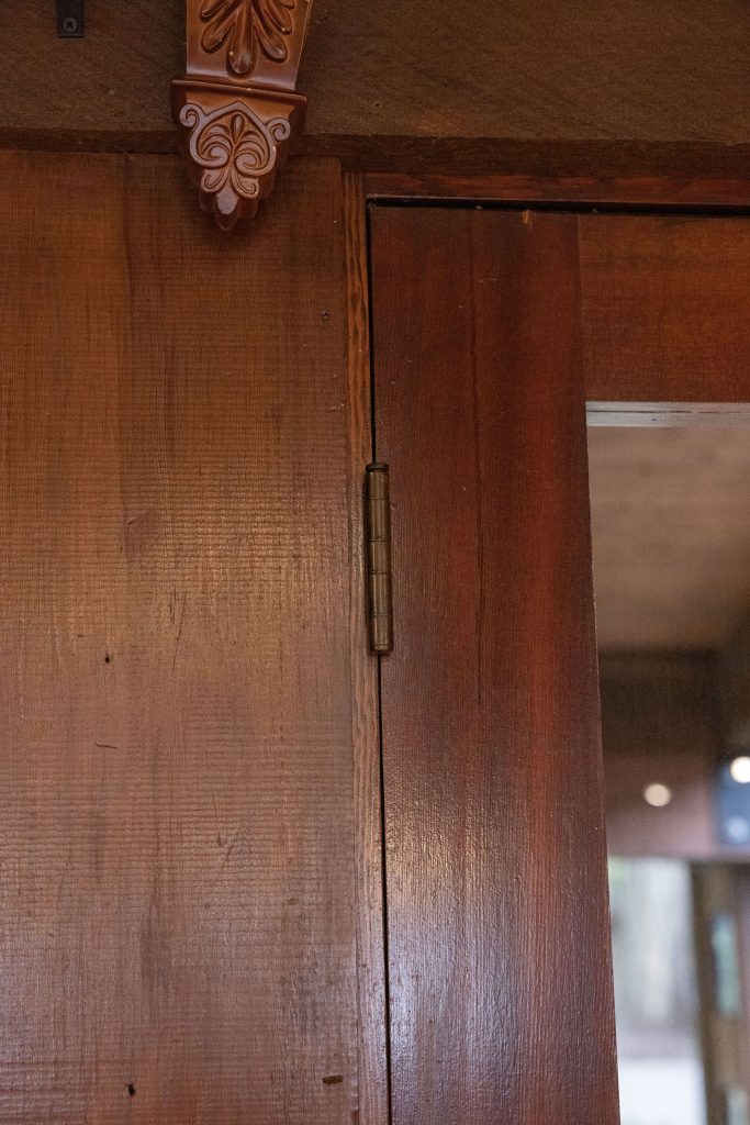 Door hinge mounted on wooden wall