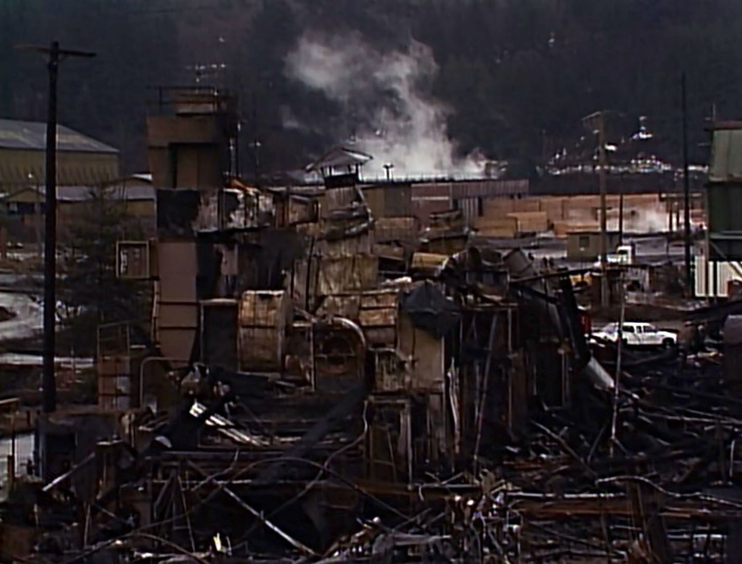 Morning after mill fire with smoking debris