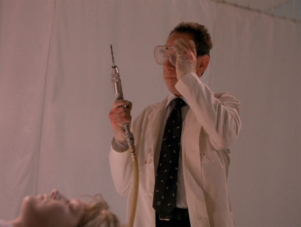 Albert Rosenfield holding a drill above Laura Palmer's body in the morgue