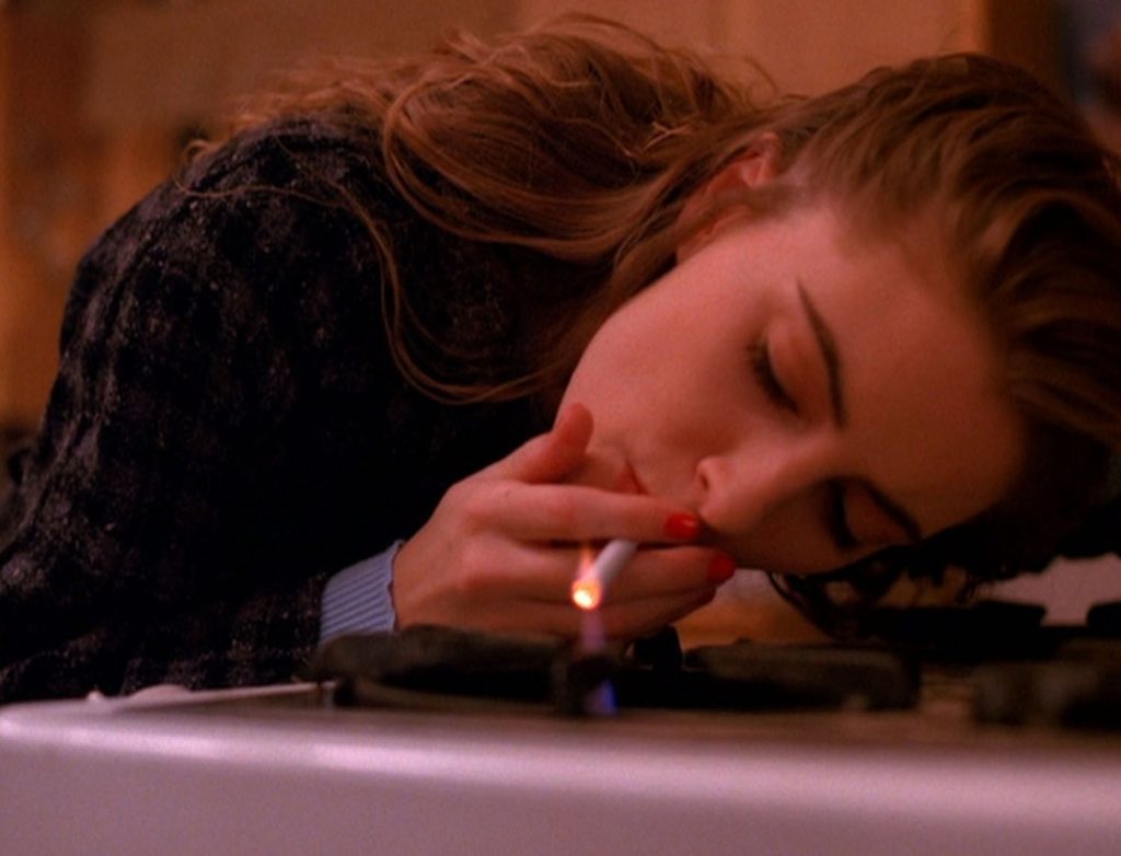 Shelly Johnson lighting cigarette from stove top