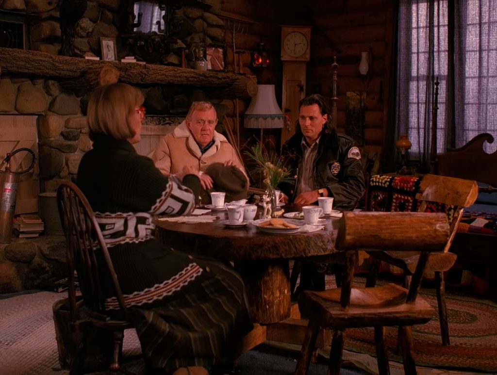 Law enforcement team sitting around the table with the Log Lady