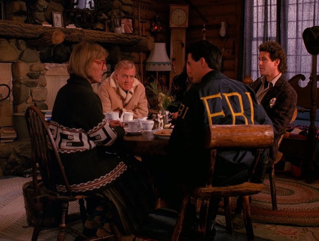 Law enforcement team sitting around the table with the Log Lady