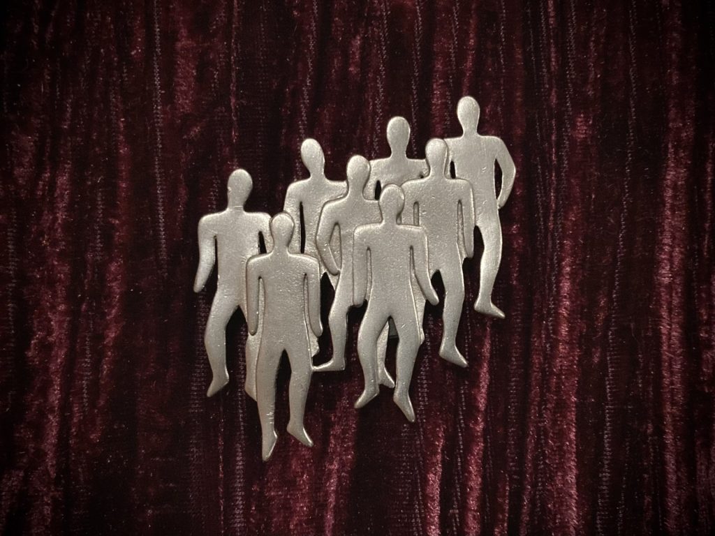 Silver brooch of group of people standing