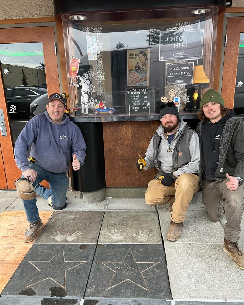 Three contractors outside North Bend Theatre