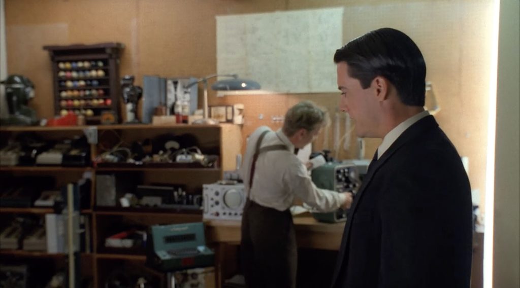 Agent Cooper speaks with Agent Stanley in his workshop