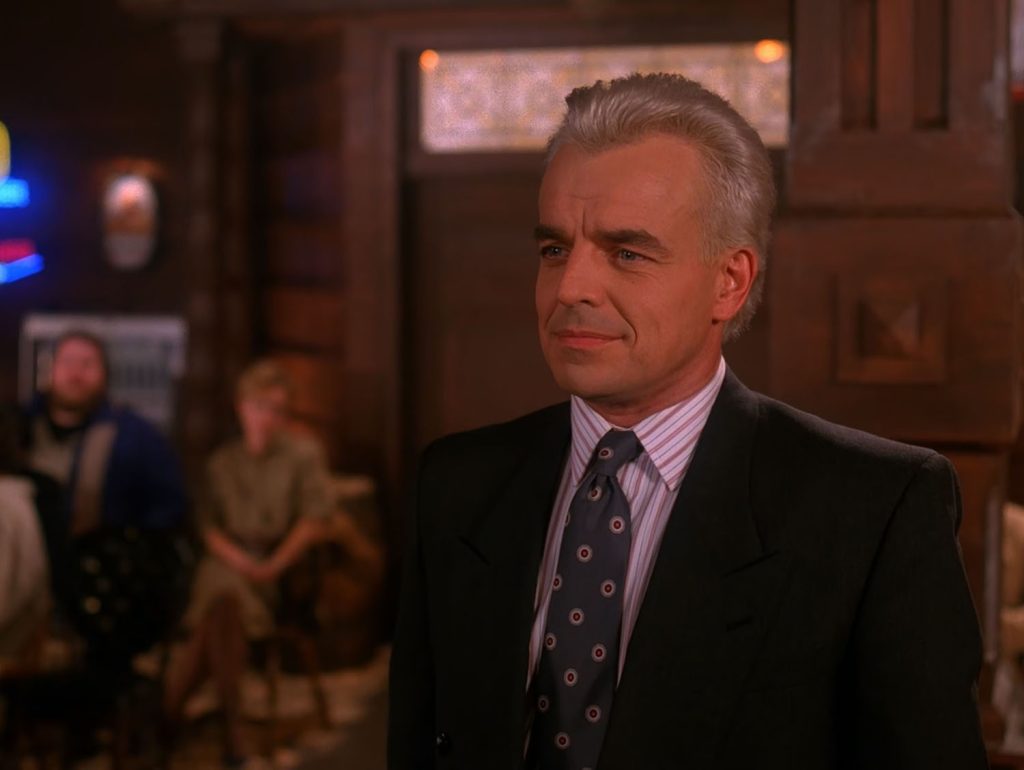 Leland Palmer standing in the Inside of the Roadhouse set up like a courtroom