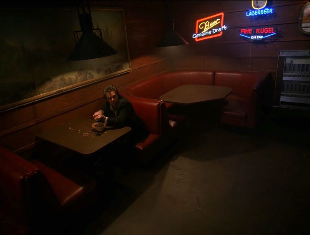 Ben Horne eating nuts in a booth at the Roadhouse