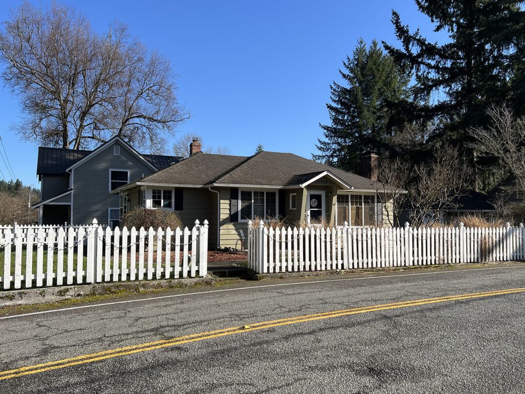 Outside of a home surrounded by a white picket fence