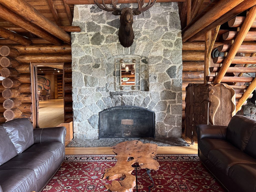 A stone fireplace with couches and a table nearby