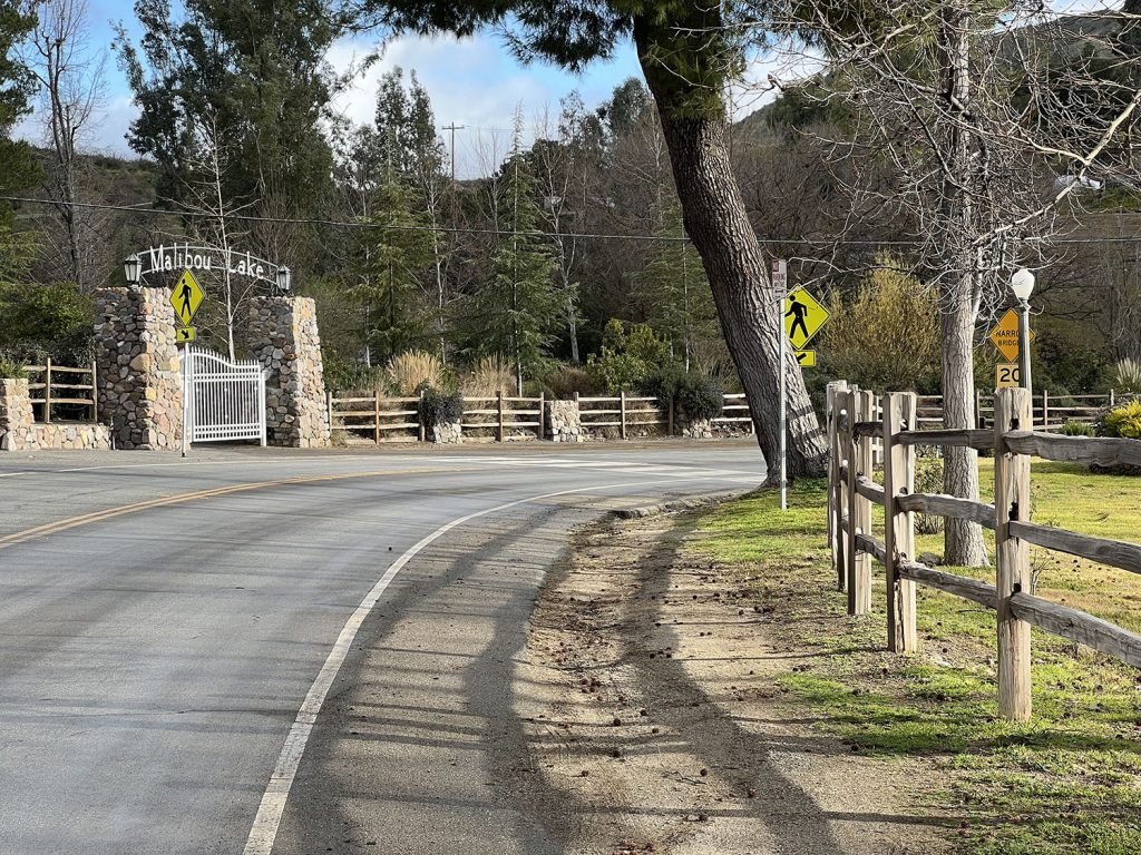 The side of a road near a wooden fence