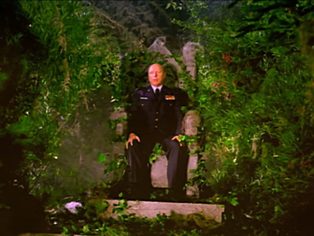 Major Briggs sitting on a throne in the woods