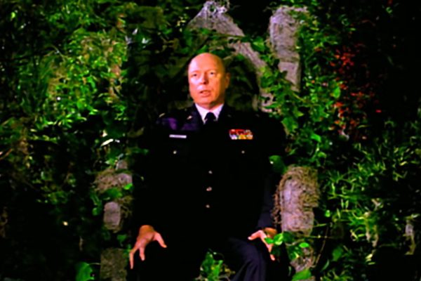 Major Briggs sitting on a stone throne in the woods