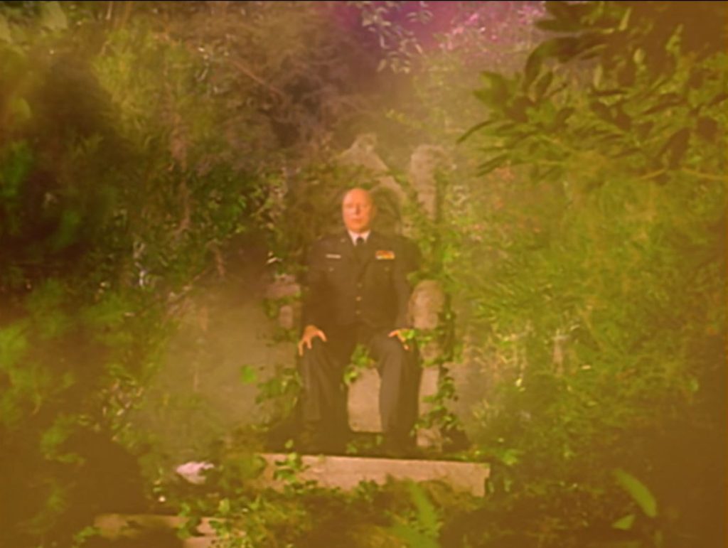 Flames with Major Briggs sitting on a throne in the woods