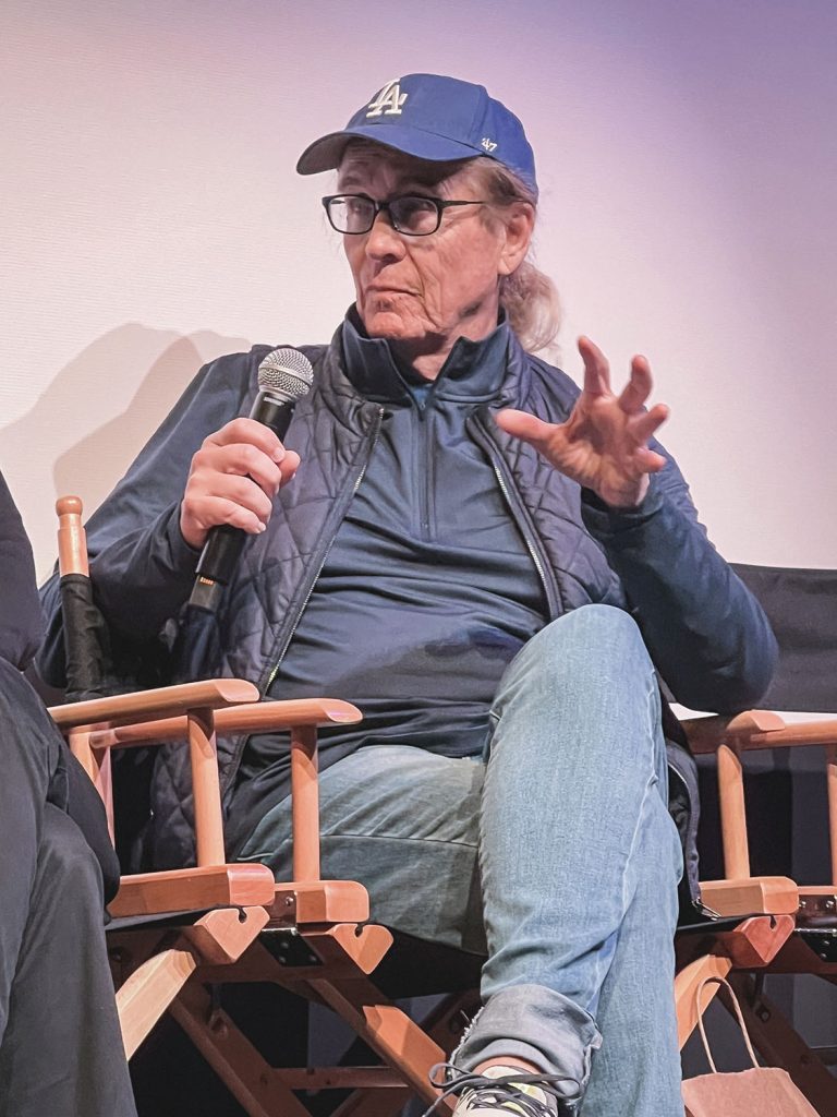 Mark Frost holding a microphone on stage