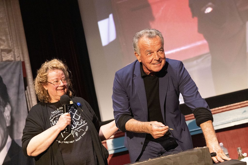 Ray Wise signing his name while Beth Burrows looks on