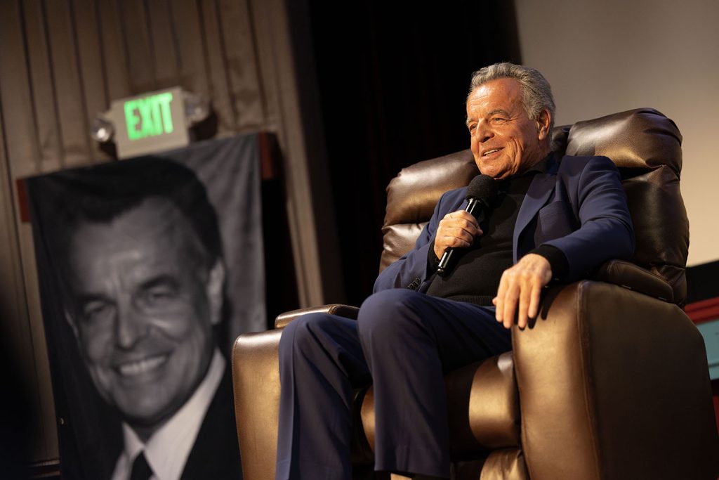 Ray Wise sitting in a chair onstage