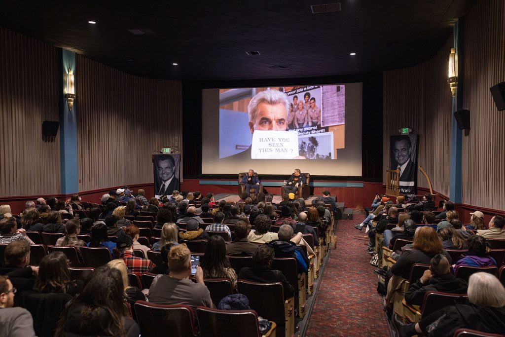 Inside of North Bend Theatre with audience watching Ray Wise and Mike McGraner speak