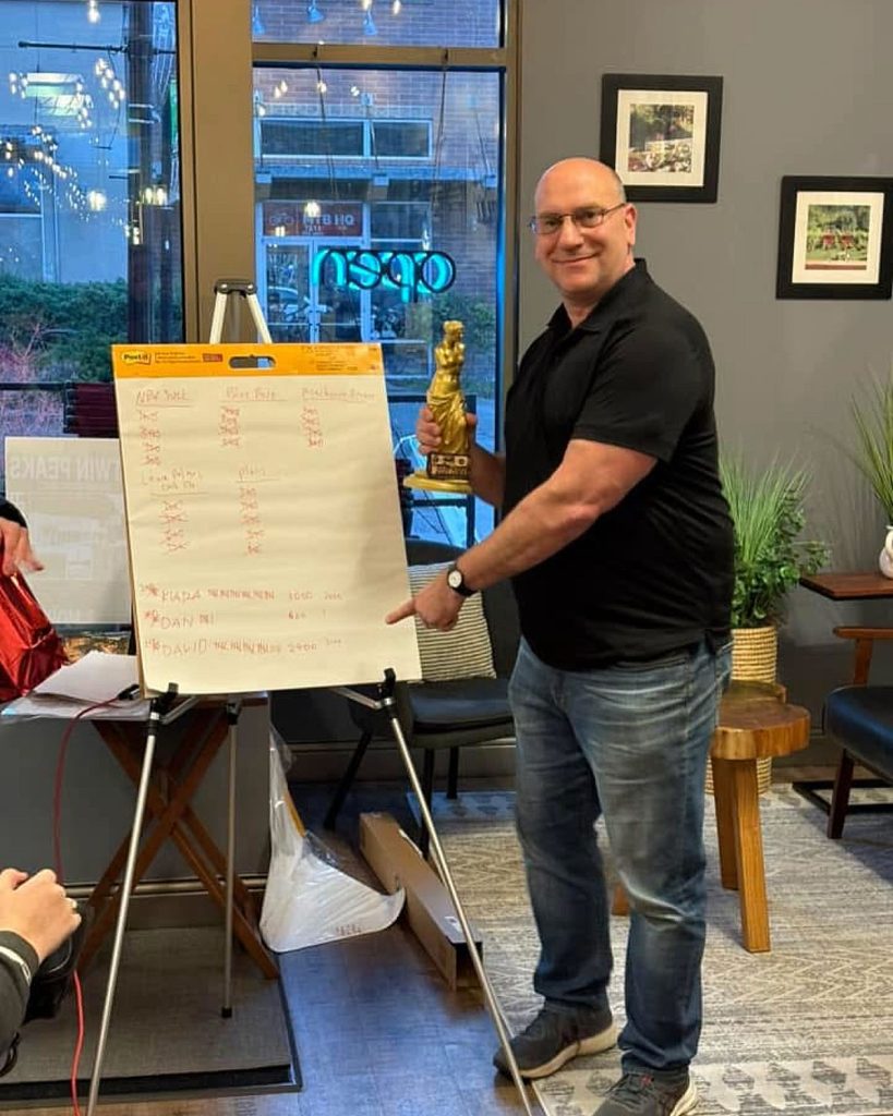 David Guarente standing next to a paper board holding the trophy