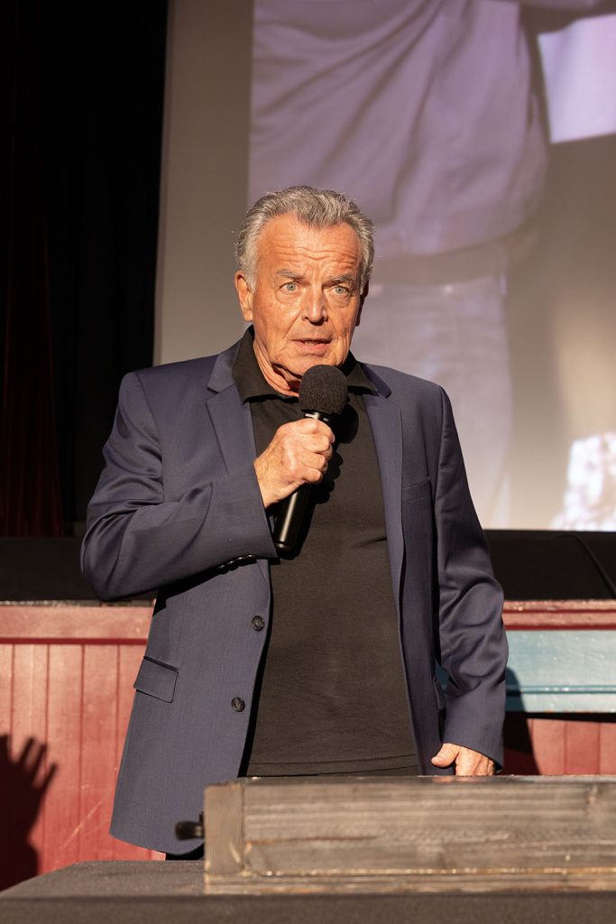 Ray Wise speaking to the audience on a microphone