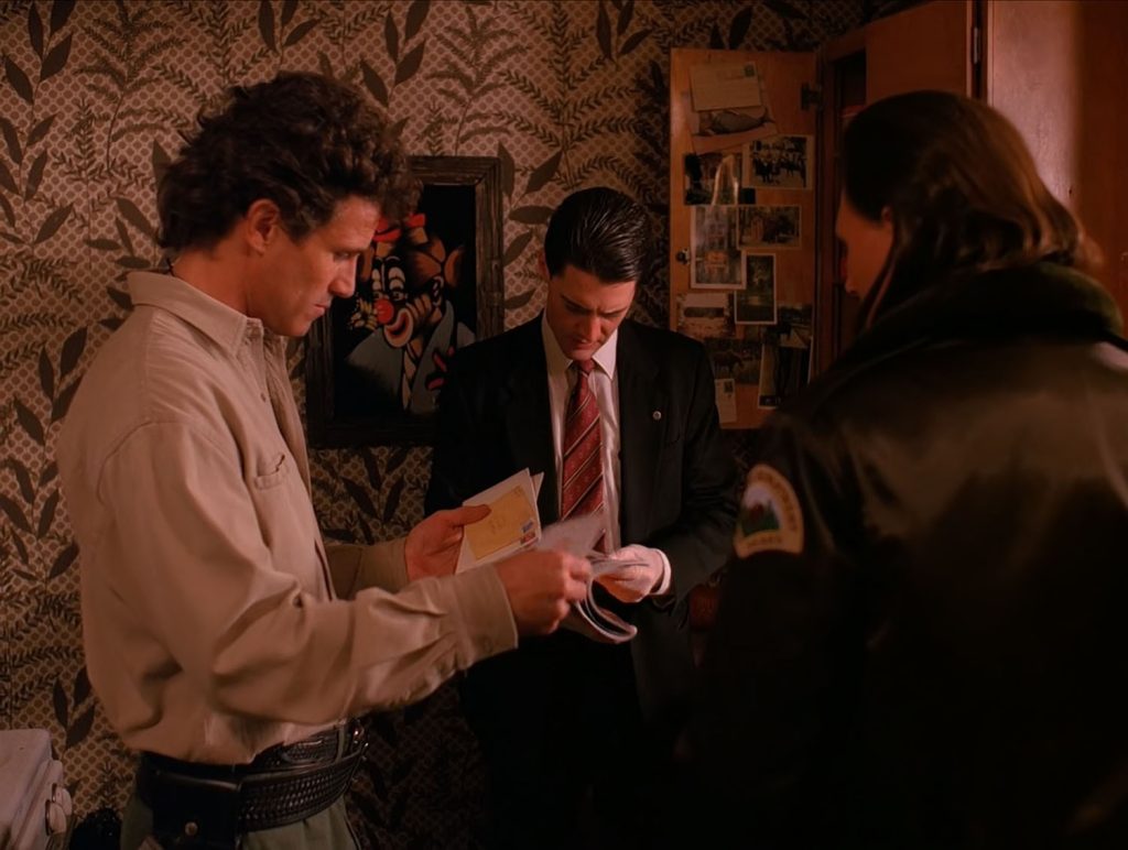 Agent Cooper, Sheriff Truman and Deputy Hawk looking at Jacques' Mail