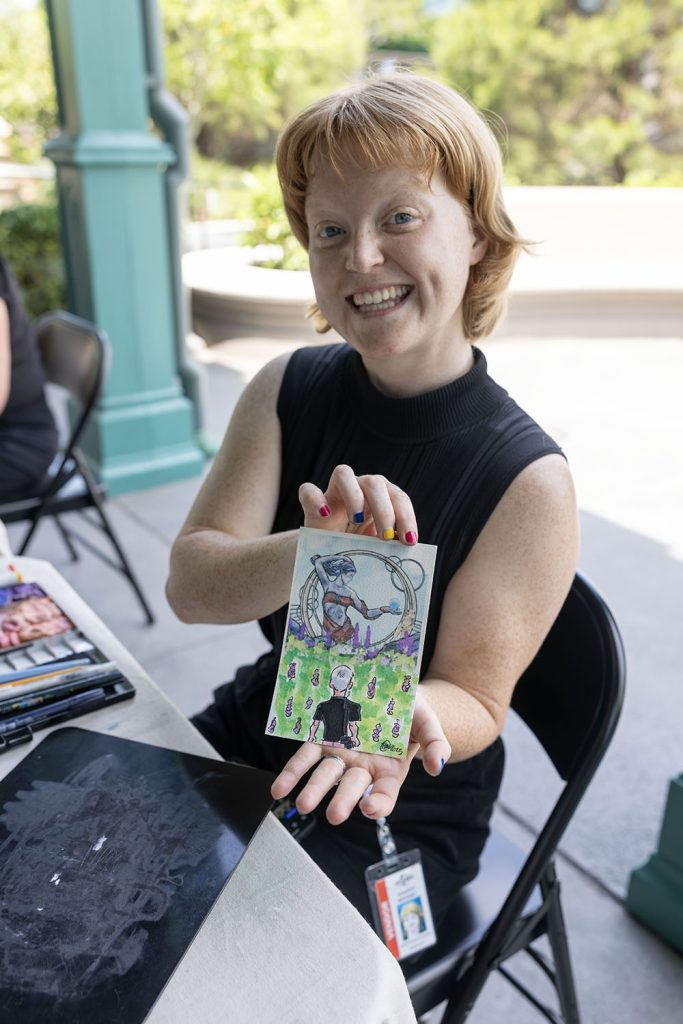 Haleigh Mooney holding Epic Universe postcard