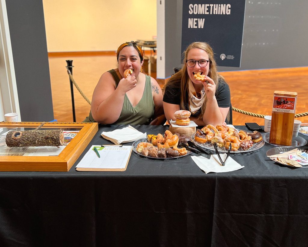 Alli Gannett and volunteer Vanessa eating doughnuts