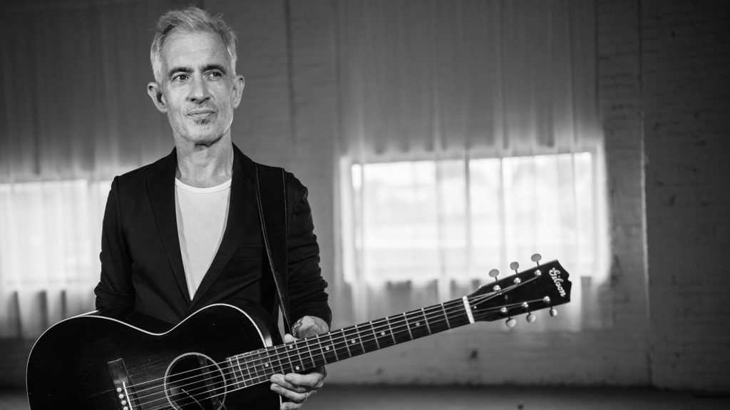 Scott E. Moore holding a guitar