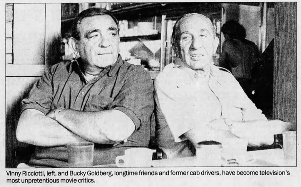 Vinny and Bucky seated at a table in a restaurant