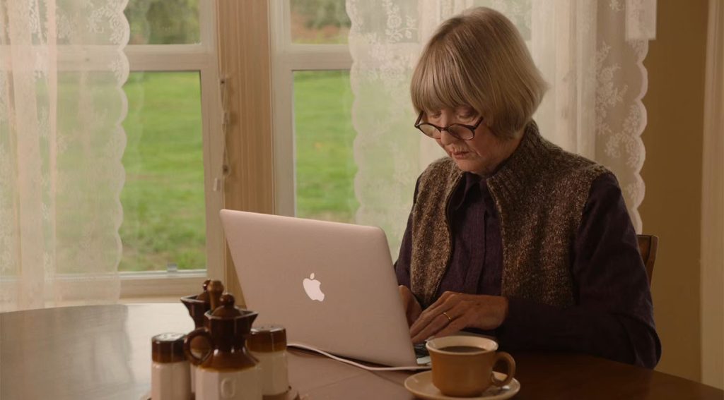 Betty Briggs sitting at a table with a computer