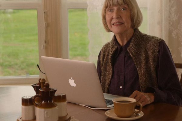 Betty Briggs sitting at a table with a computer