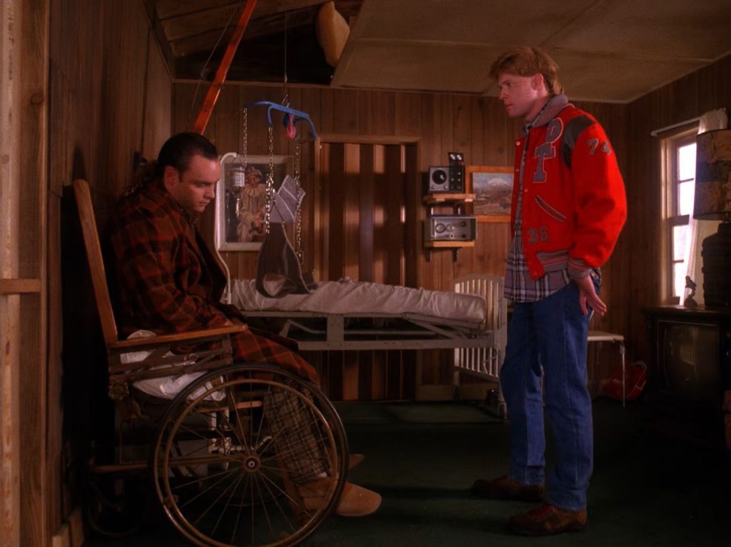 Mike and Bobby looking at a tape with Leo Johnson in a wheelchair