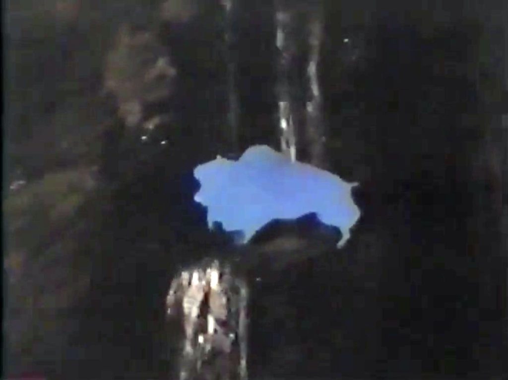 Blue wooden buffalo cutout by a waterfall