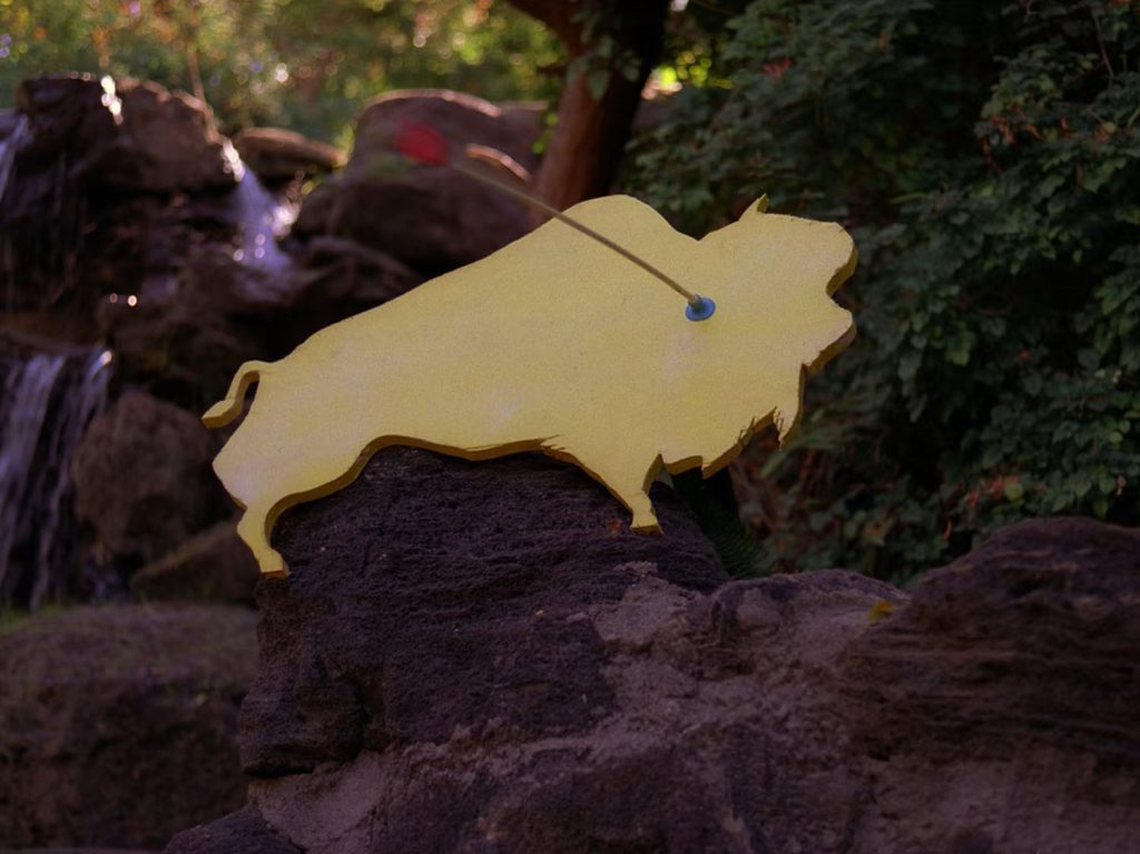 Yellow buffalo cutout on rocks with toy dart