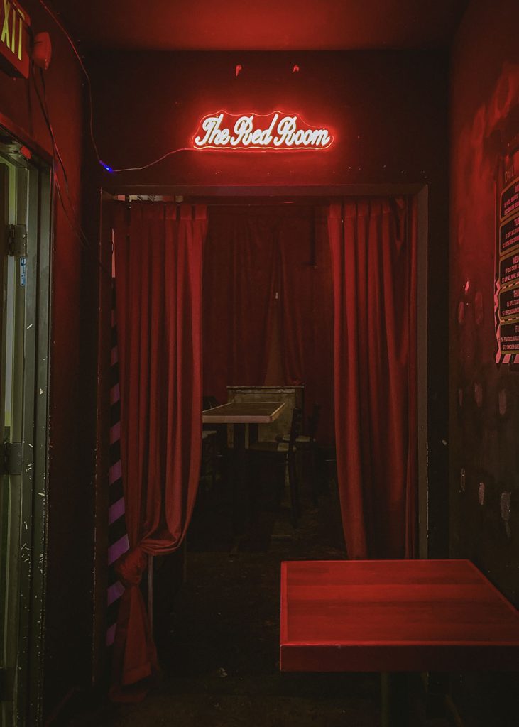 The Red Room venue with red drapes and an neon sign