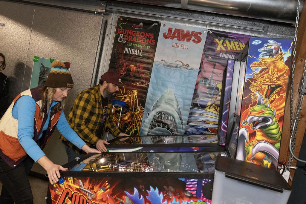 People playing pinball at Volition Brewing Co.