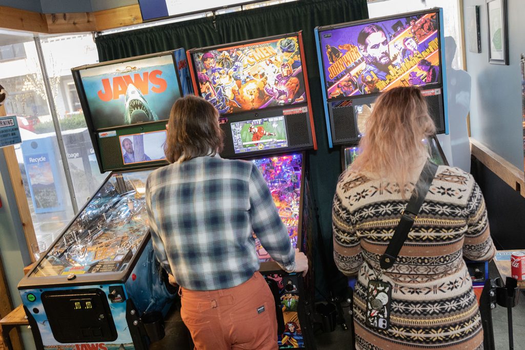 People playing pinball at Volition Brewing Co.