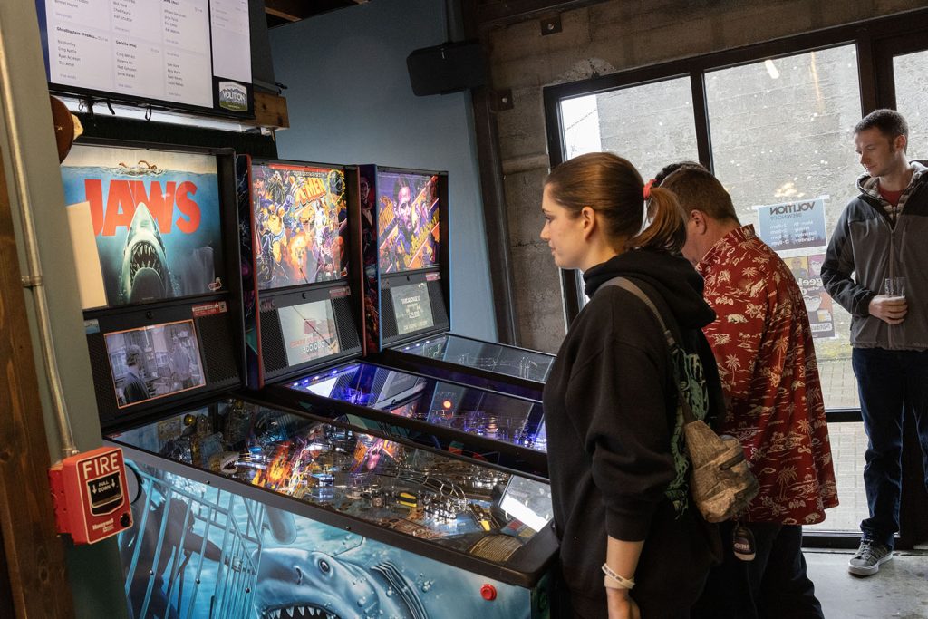 People playing pinball at Volition Brewing Co.