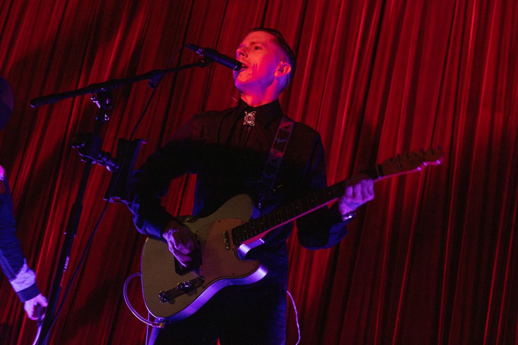 Dusty Highway playing guitar on stage at the North Bend Theatre