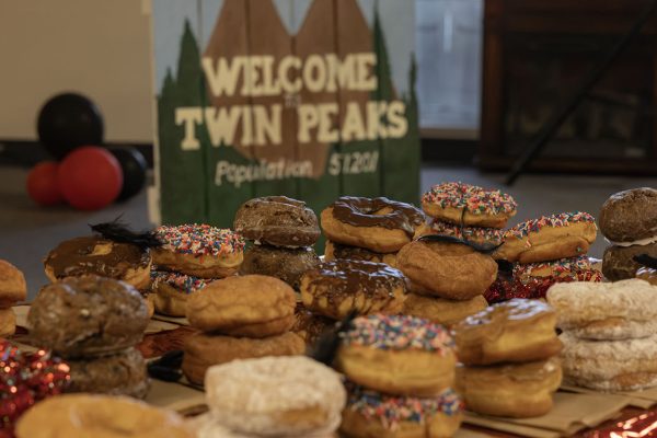 Stacks of doughnuts with "Welcome to Twin Peaks SIgn" in distance