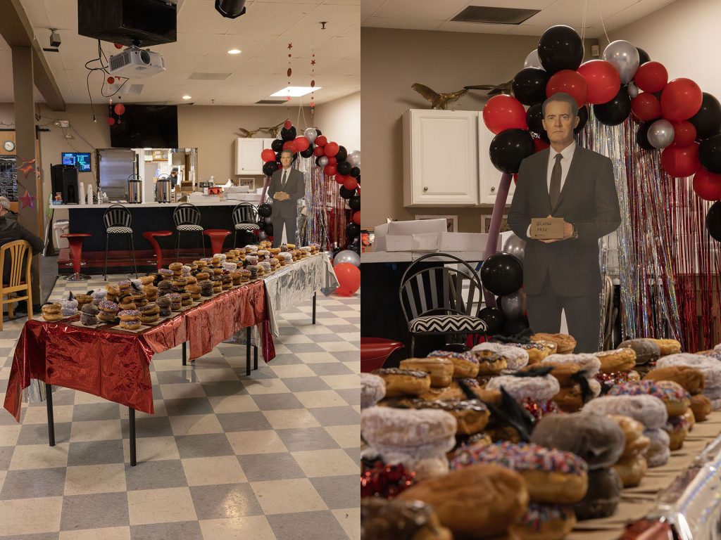 Table full of stacked doughnuts with a cut out of Cooper in the distance