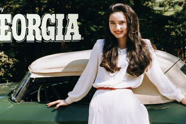 Asami standing next to a car with the "Enjoy Georgia" logo