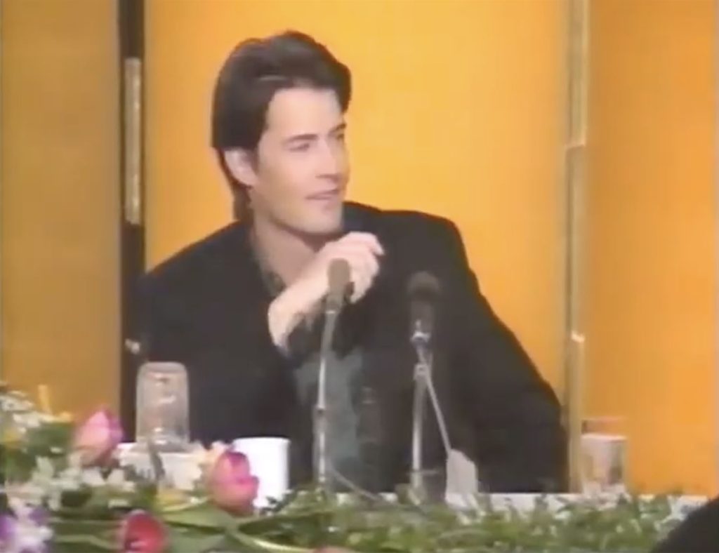 Kyle MacLachlan on stage holding a cassette recorder