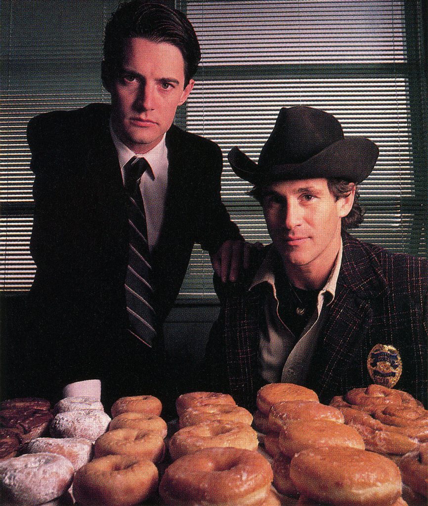Special Agent Dale Cooper and Sheriff Harry S. Truman next to stacks of doughnuts